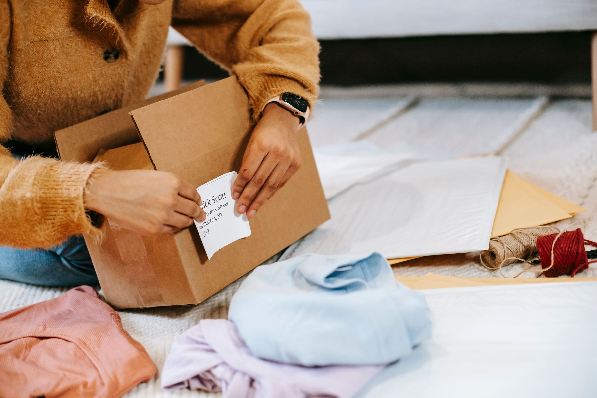 Applying an address label to a shipping box beside packing materials