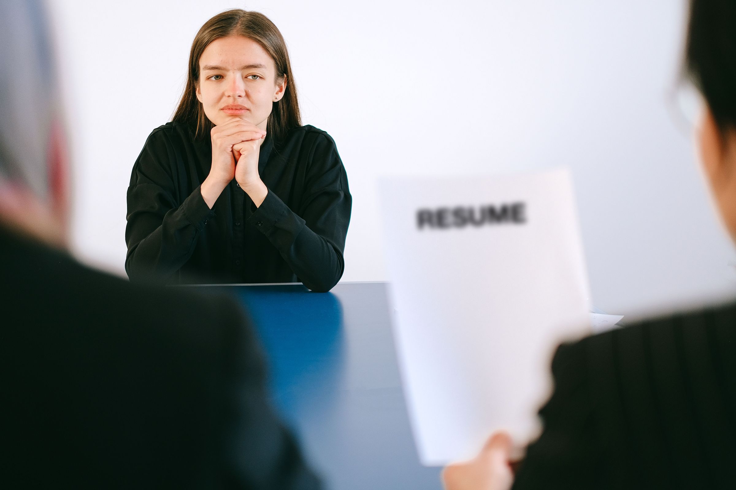 Job candidate sitting in an interview with two people and a resume