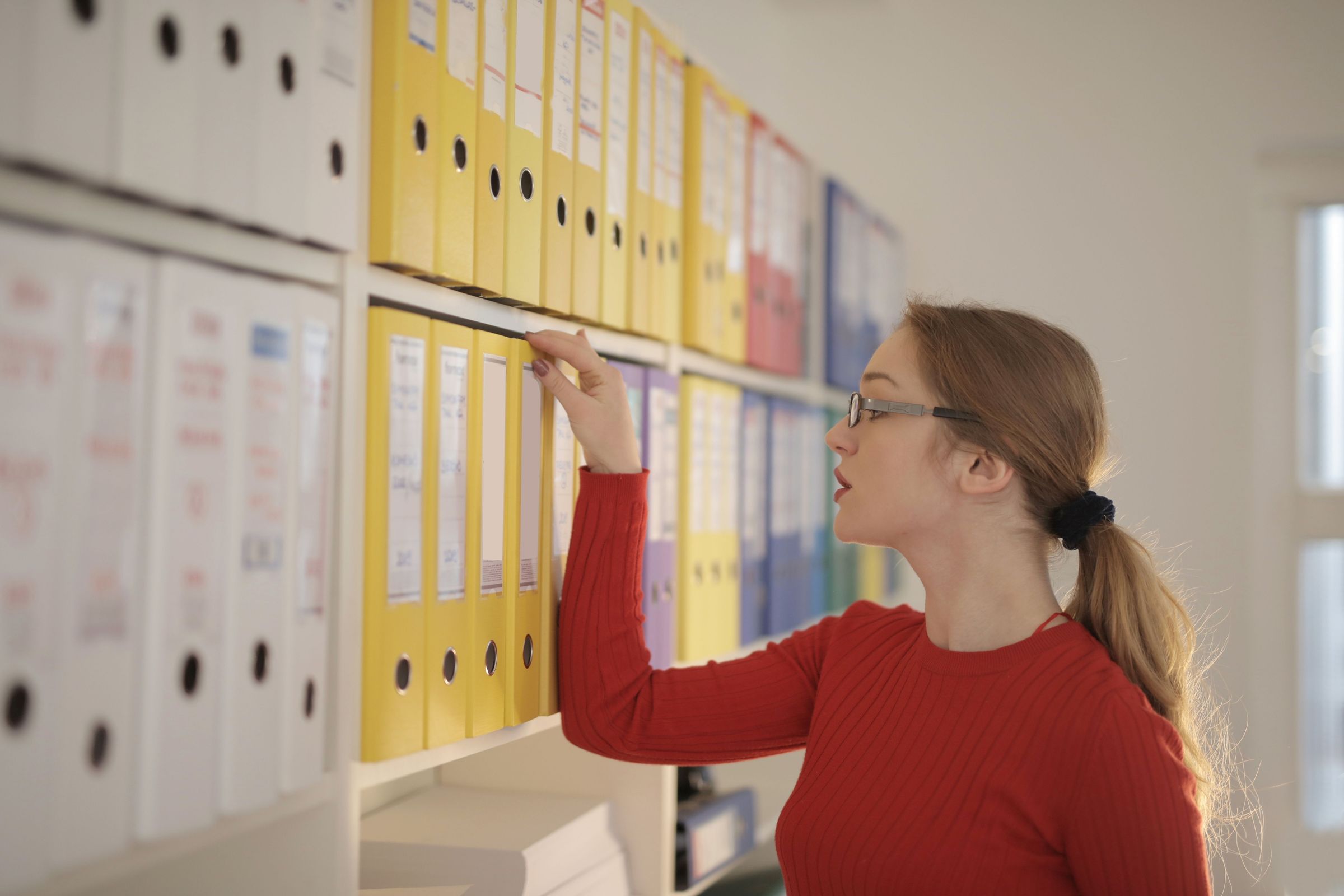 Office worker selecting a file from a paper archive
