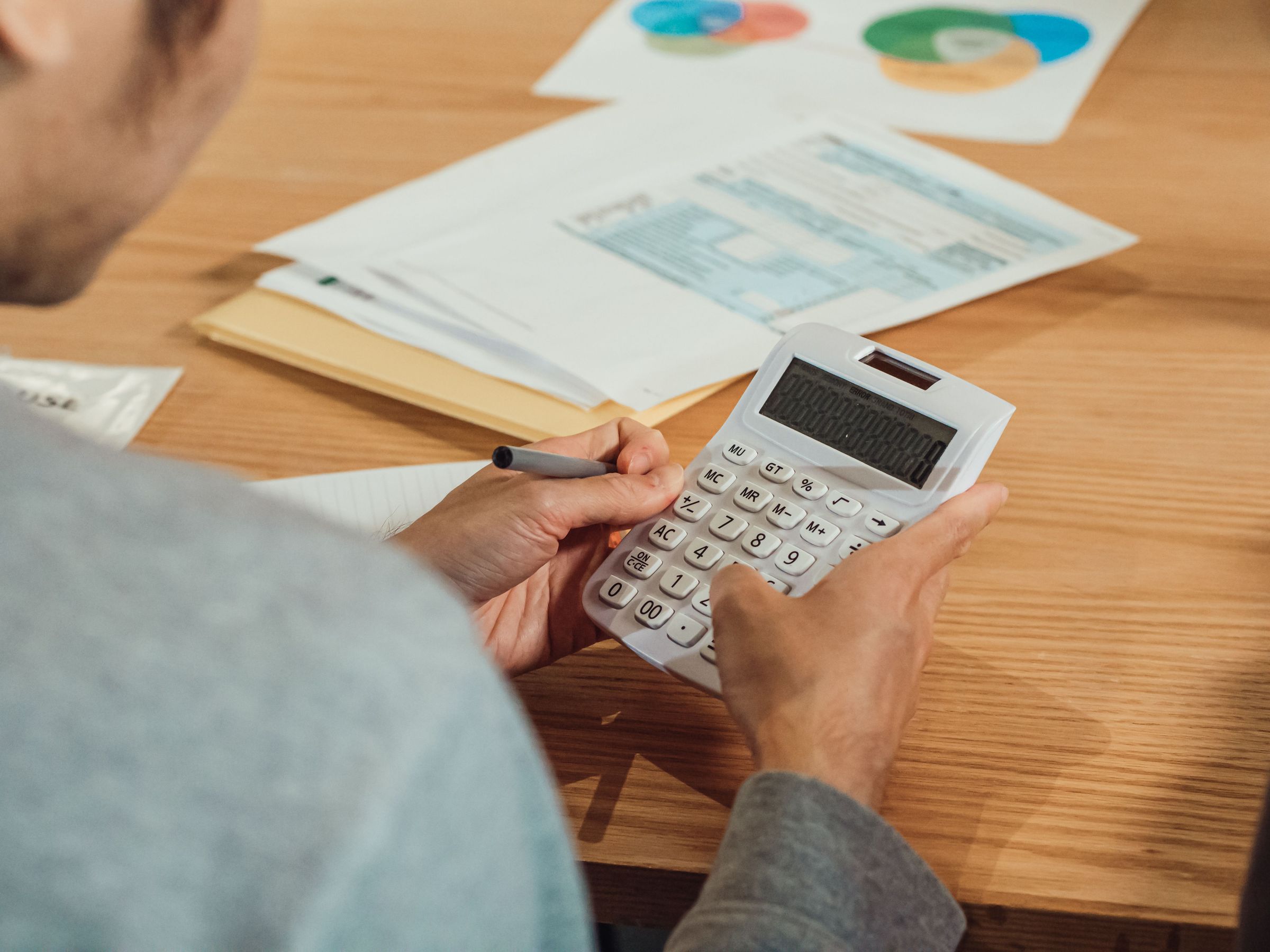 Real photograph of calculator use beside general financial papers