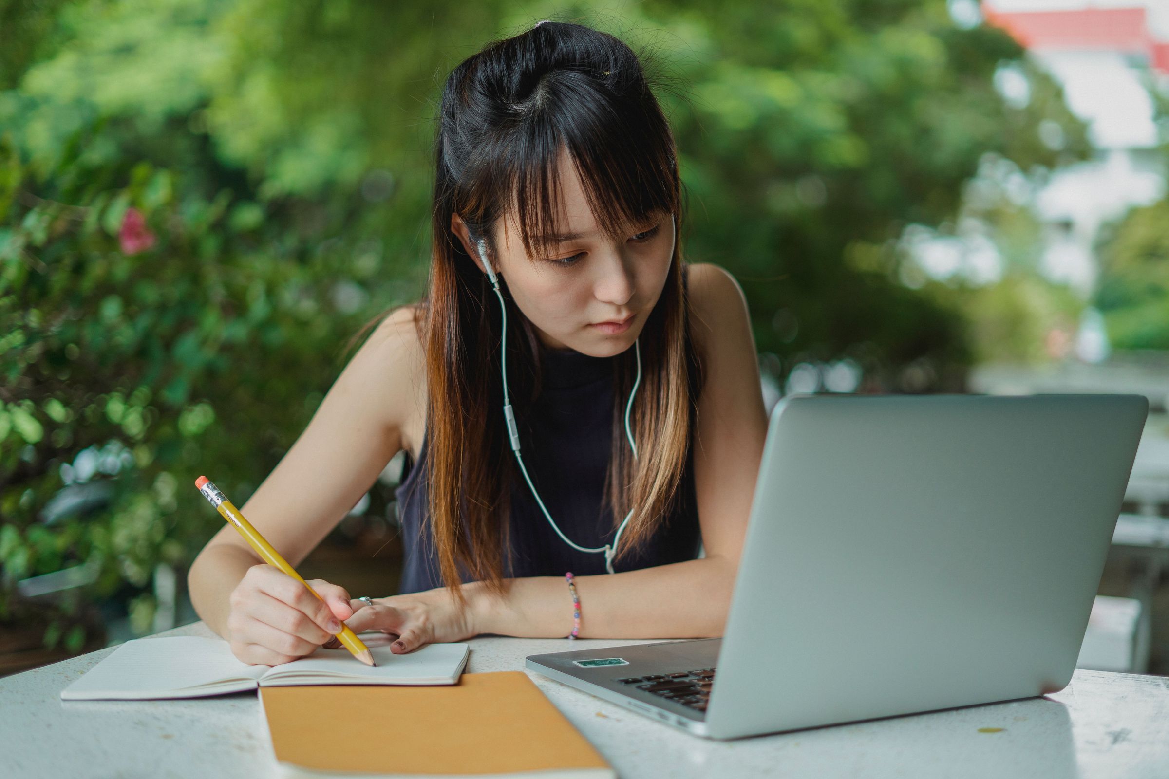 Woman studying with a laptop and notebook