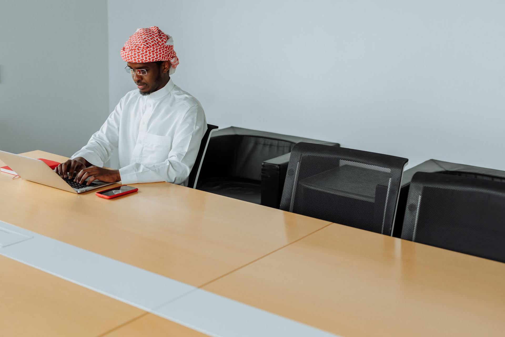 Business professional in the Sultanate of Oman using a laptop to evaluate artificial intelligence companies