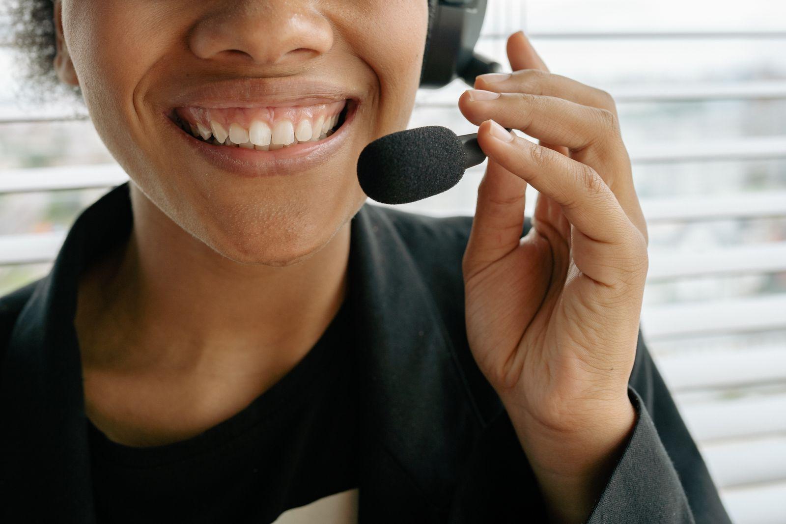 Arab customer support specialist using headphones and a laptop for automated replies