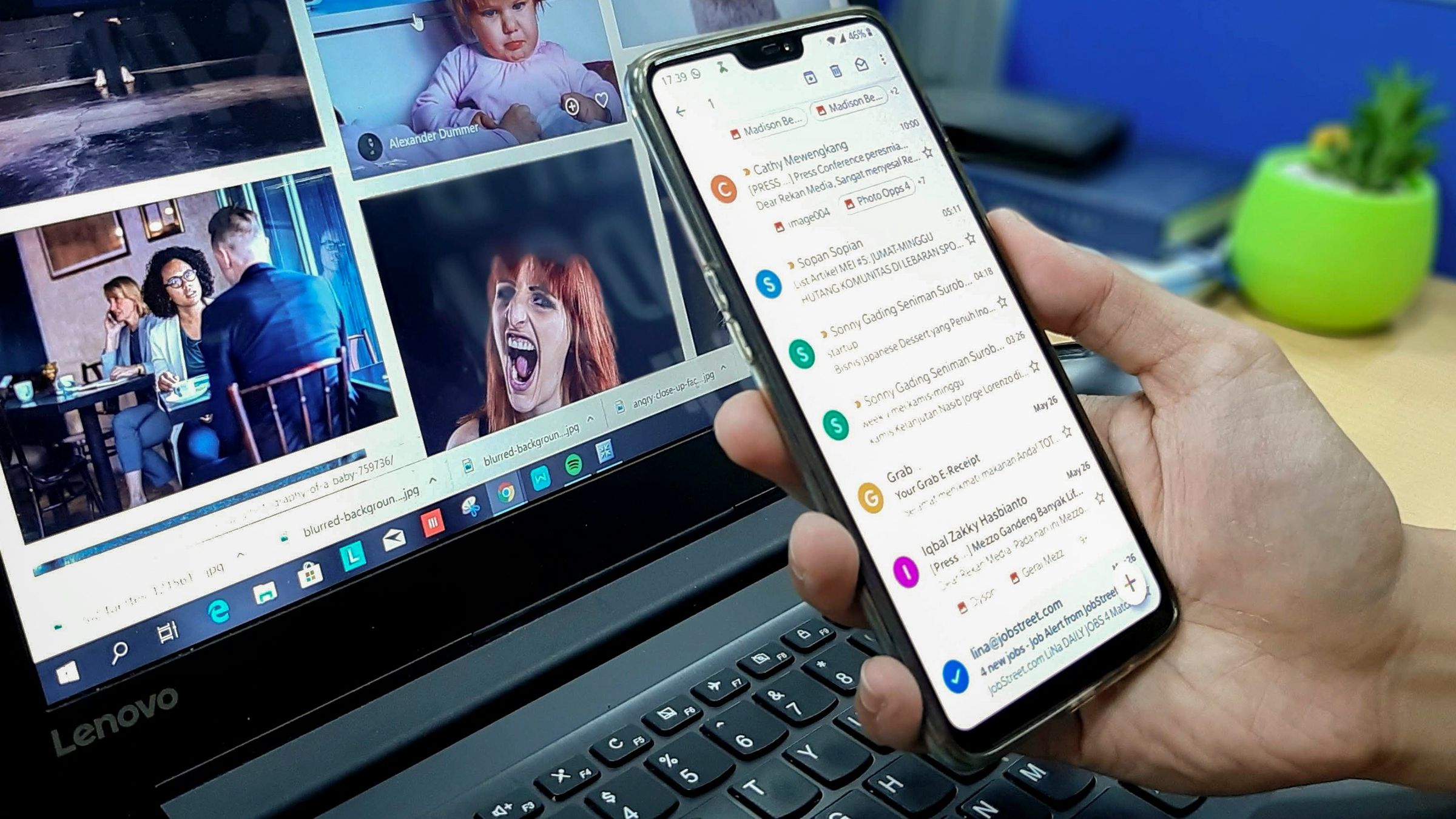 Phone displaying a Gmail inbox beside a laptop