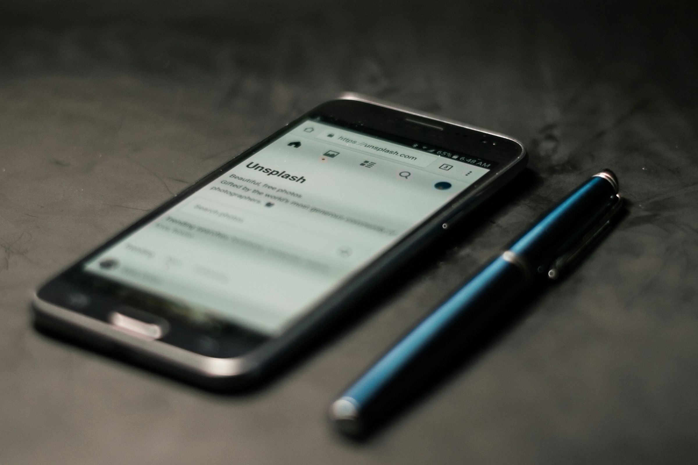 Phone displaying an Unsplash website address in its browser