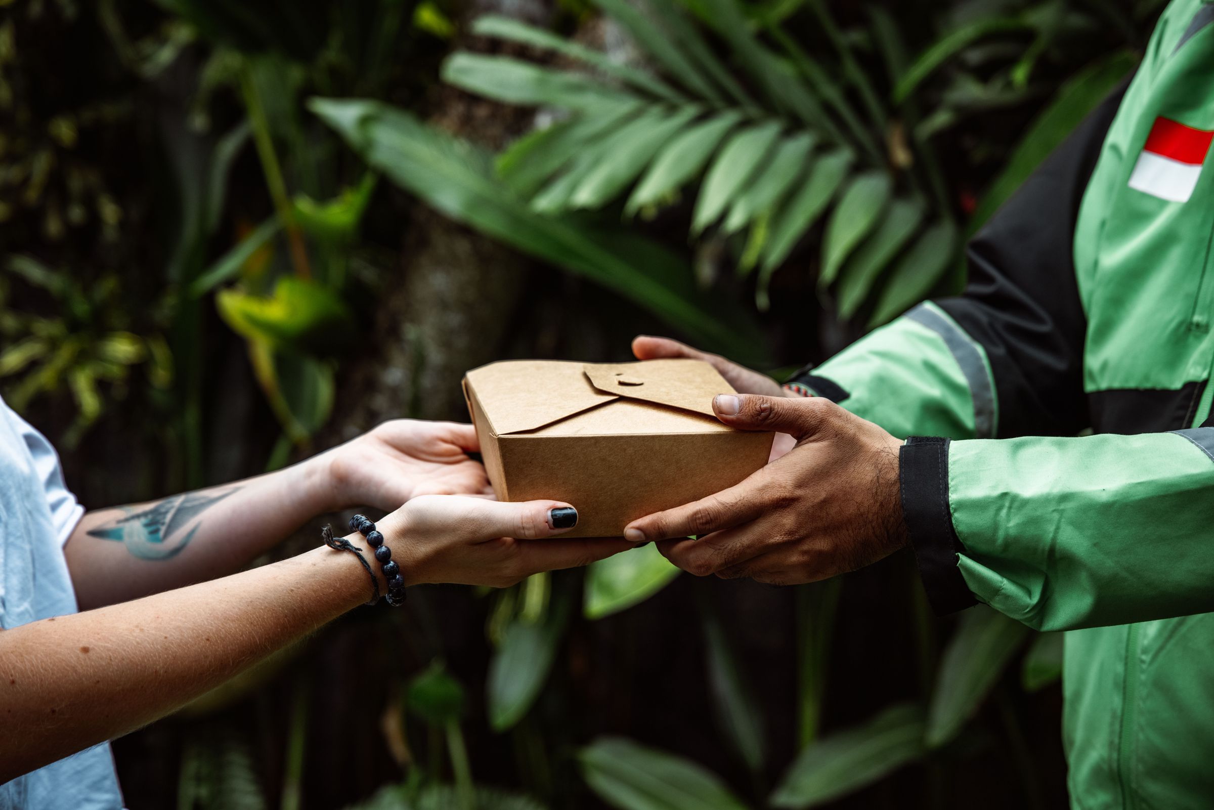 Handing a takeaway food package from courier to customer