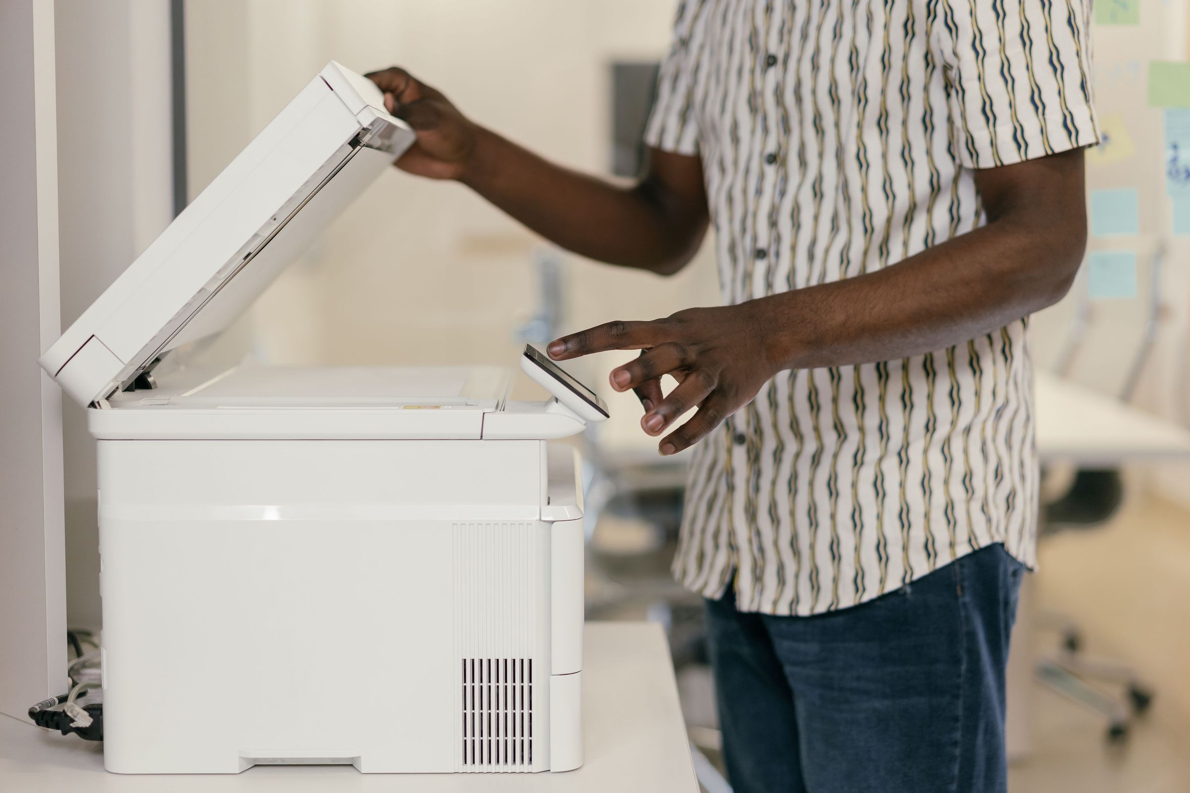 Person opening a document copier lid and using its control panel