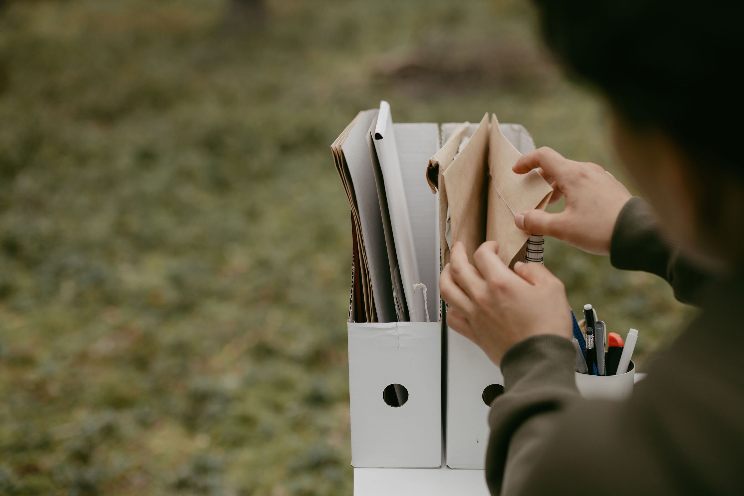 Hands choosing a paper folder from a group of folders