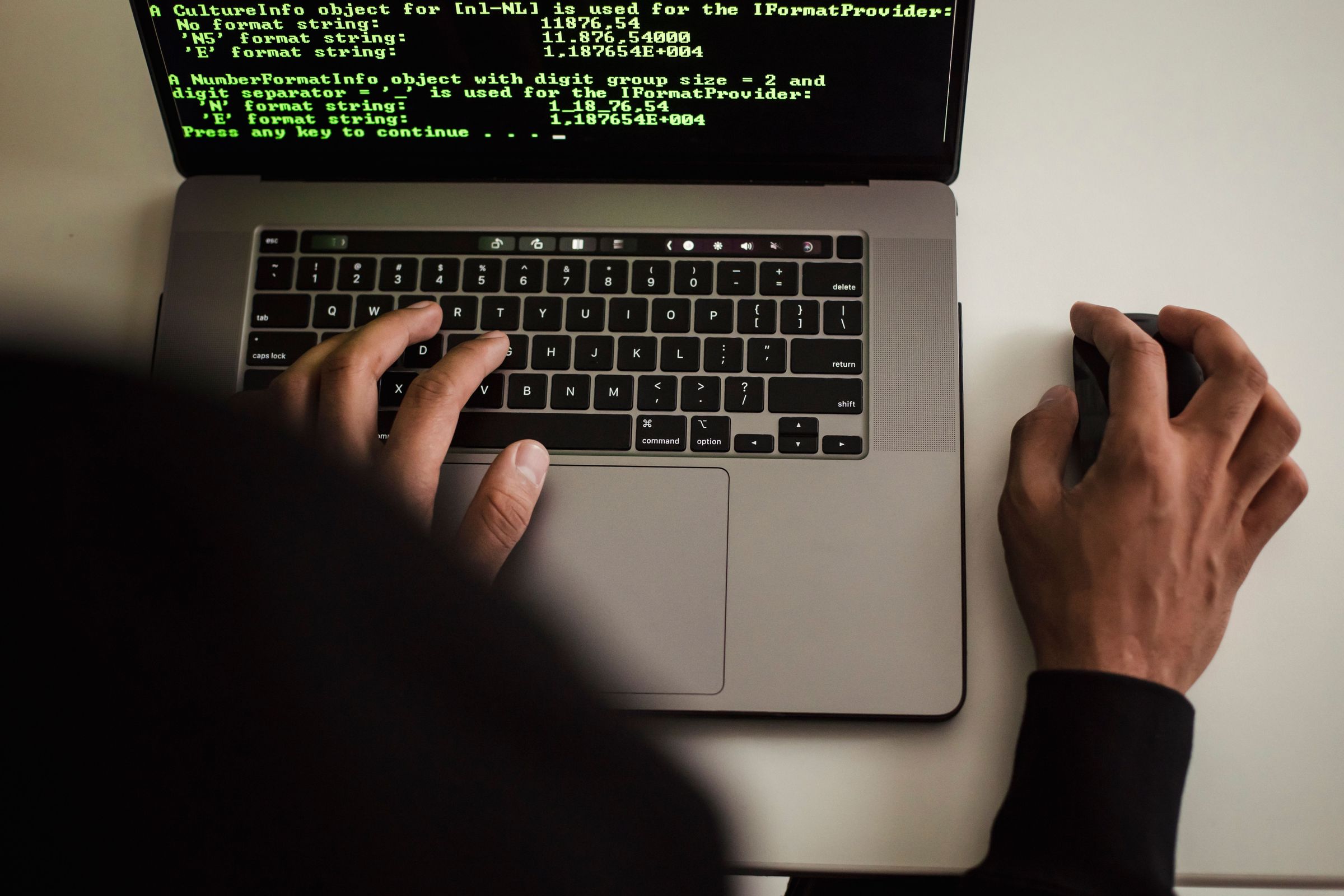 Person using a laptop displaying programming text