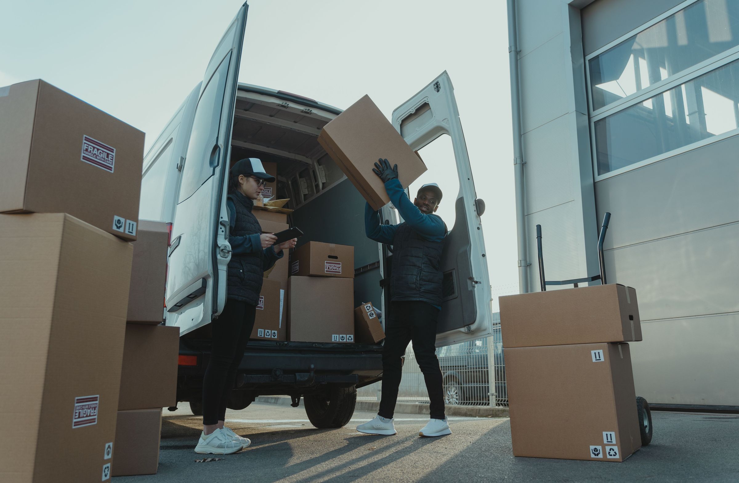 Loading boxes into a delivery vehicle near a warehouse