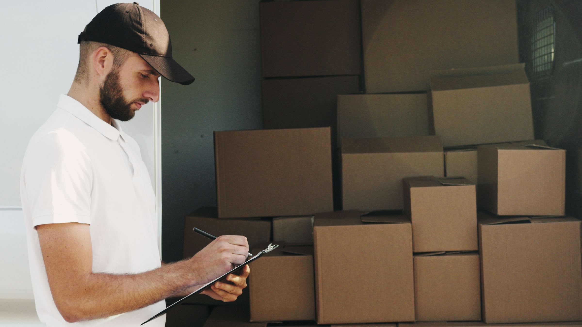 Writing paperwork beside boxes inside a vehicle