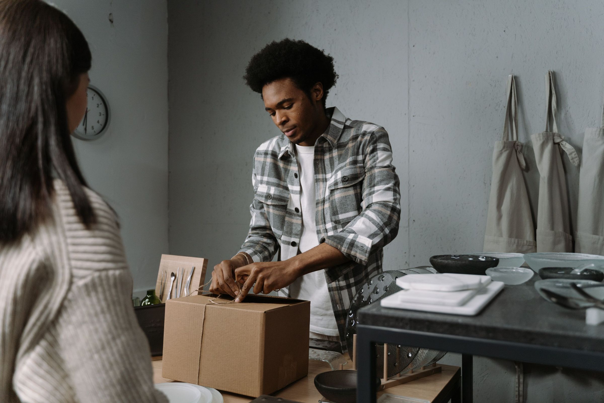 Retail worker tying a box in front of a visitor