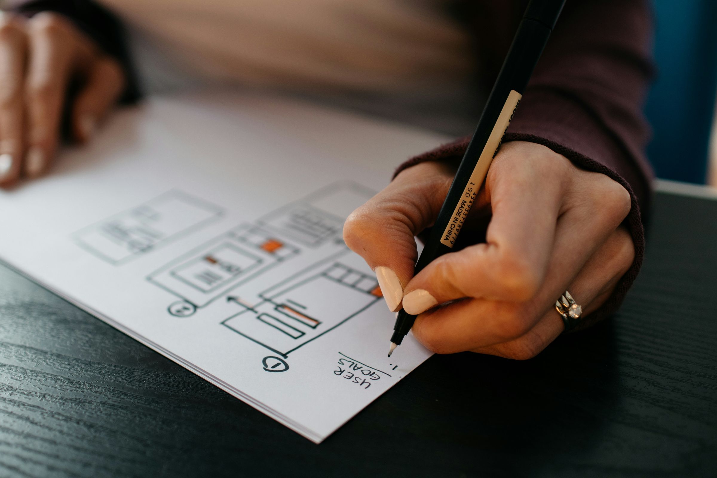 Drawing a page interface wireframe with a pen on paper