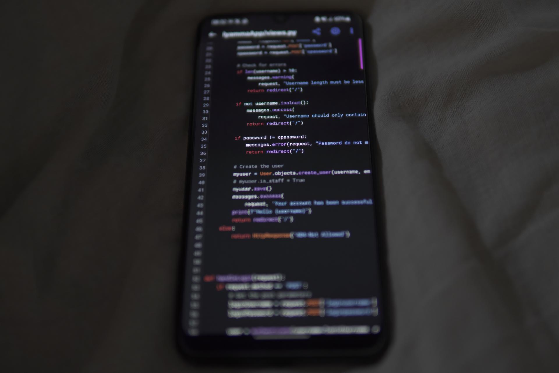 Smartphone displaying code for a mobile app technology decision