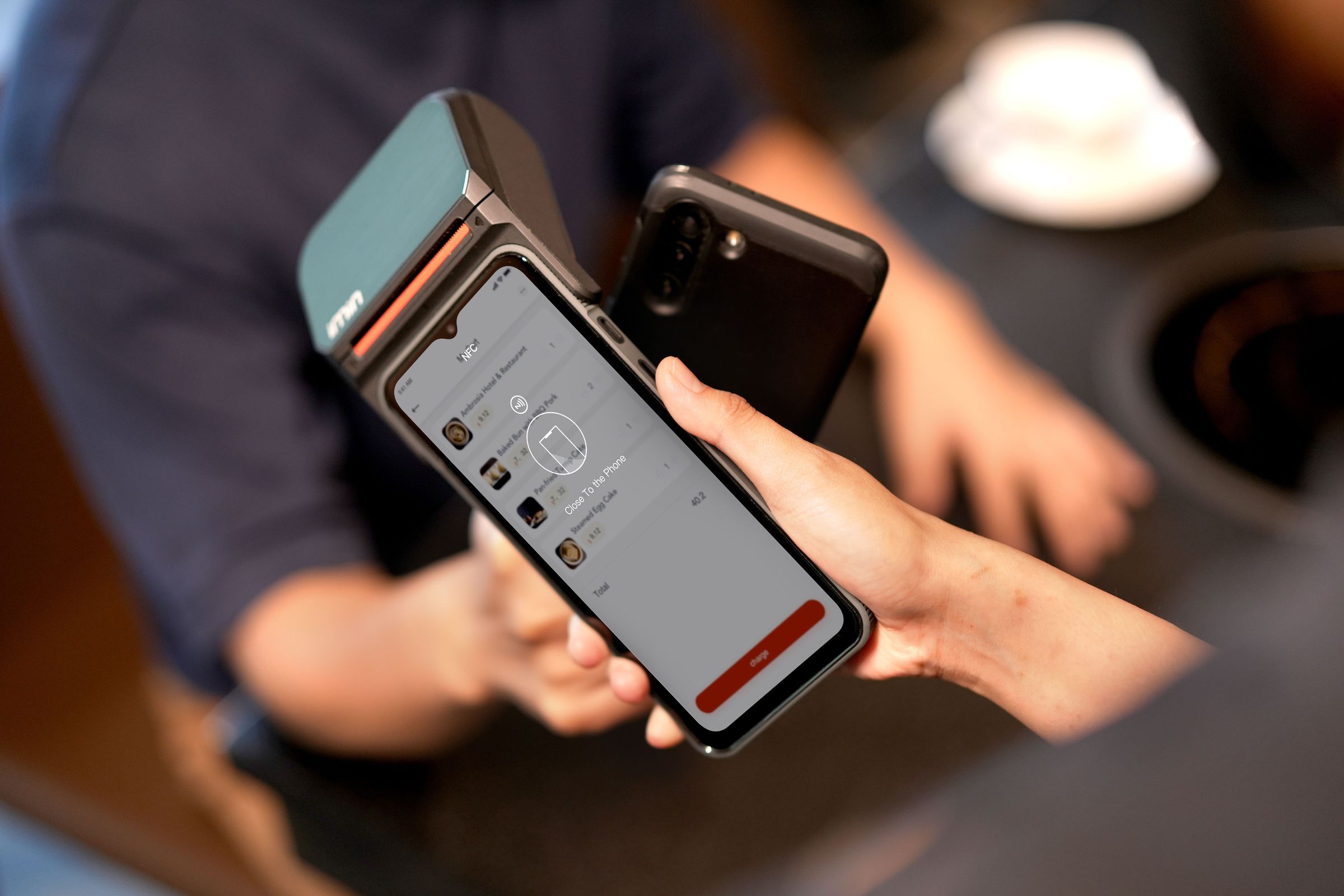 Phone near a physical payment terminal displaying an NFC prompt