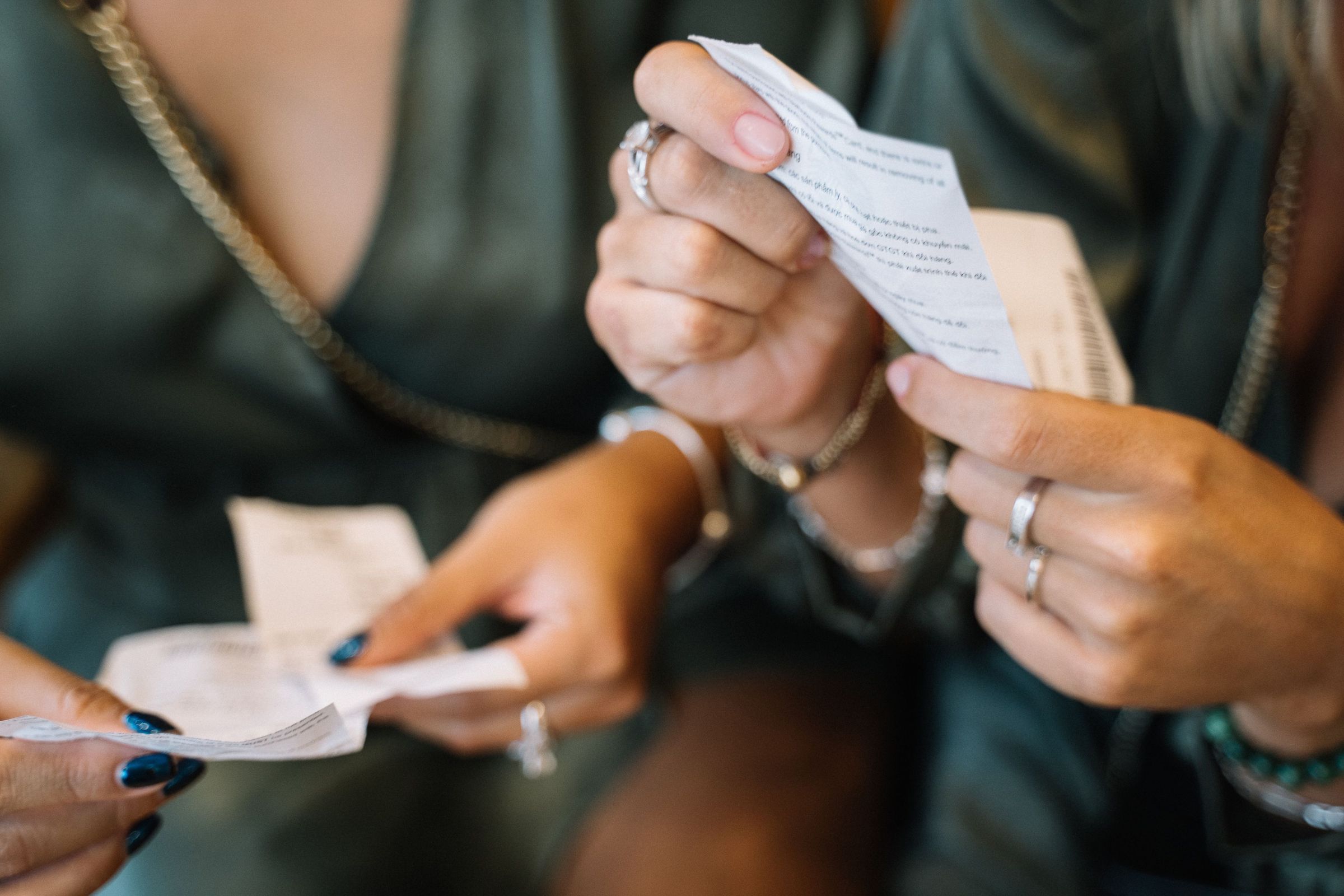 Two people reviewing printed paper receipts