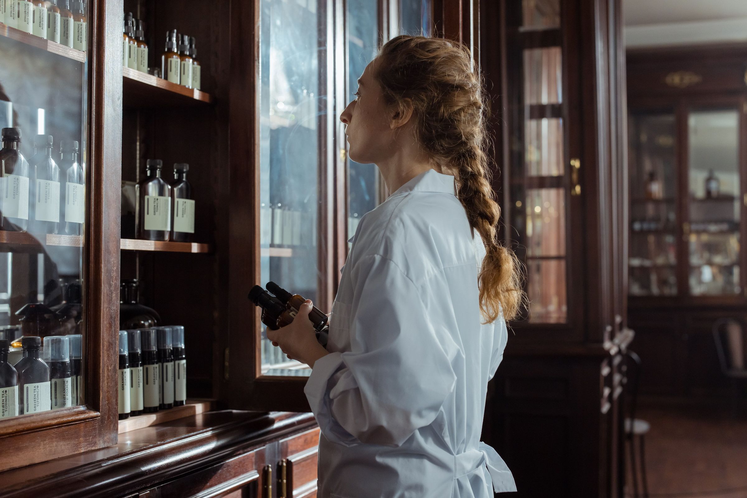 Different bottles being identified beside a traditional medicine cabinet