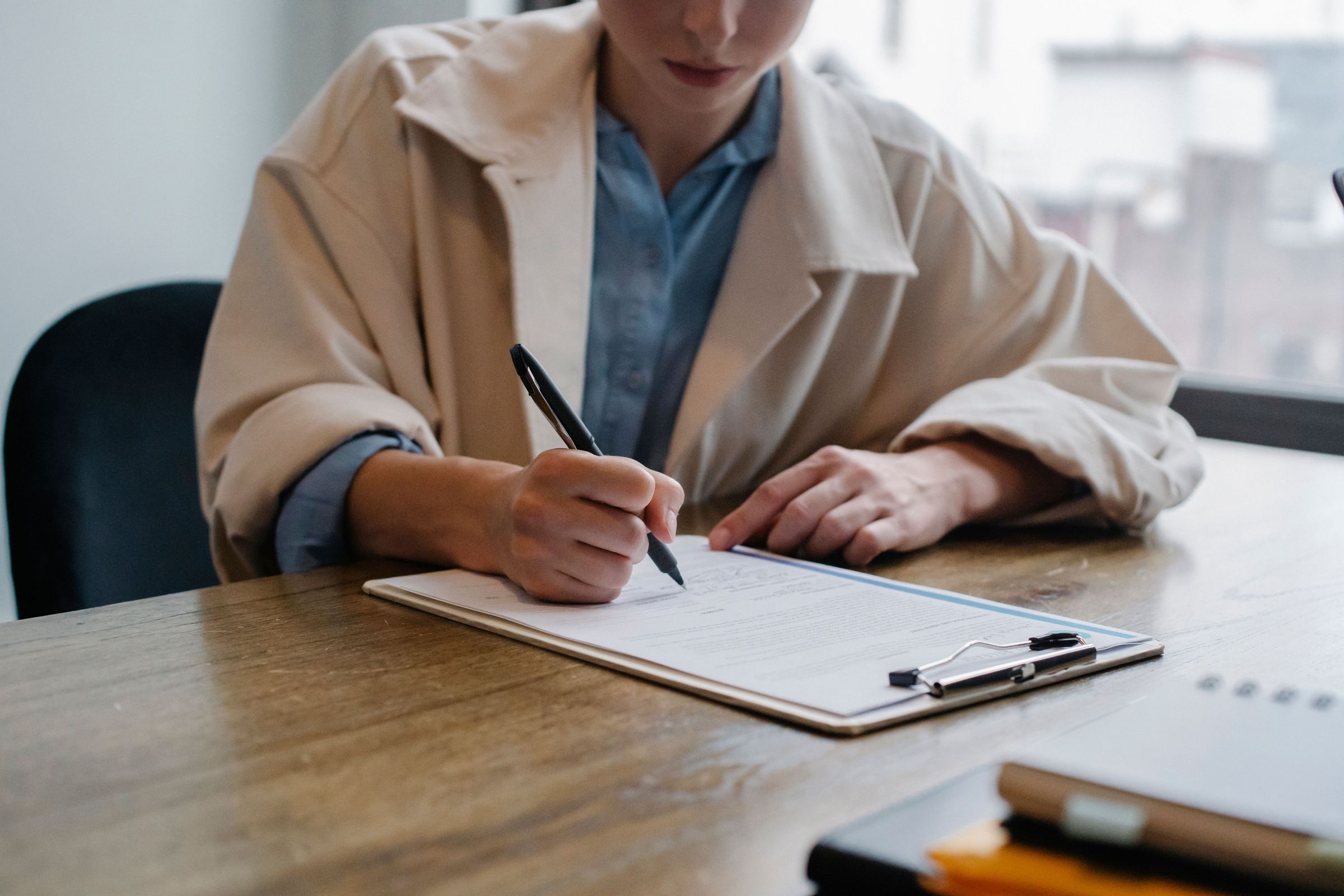 Job candidate writing in a document on a clipboard