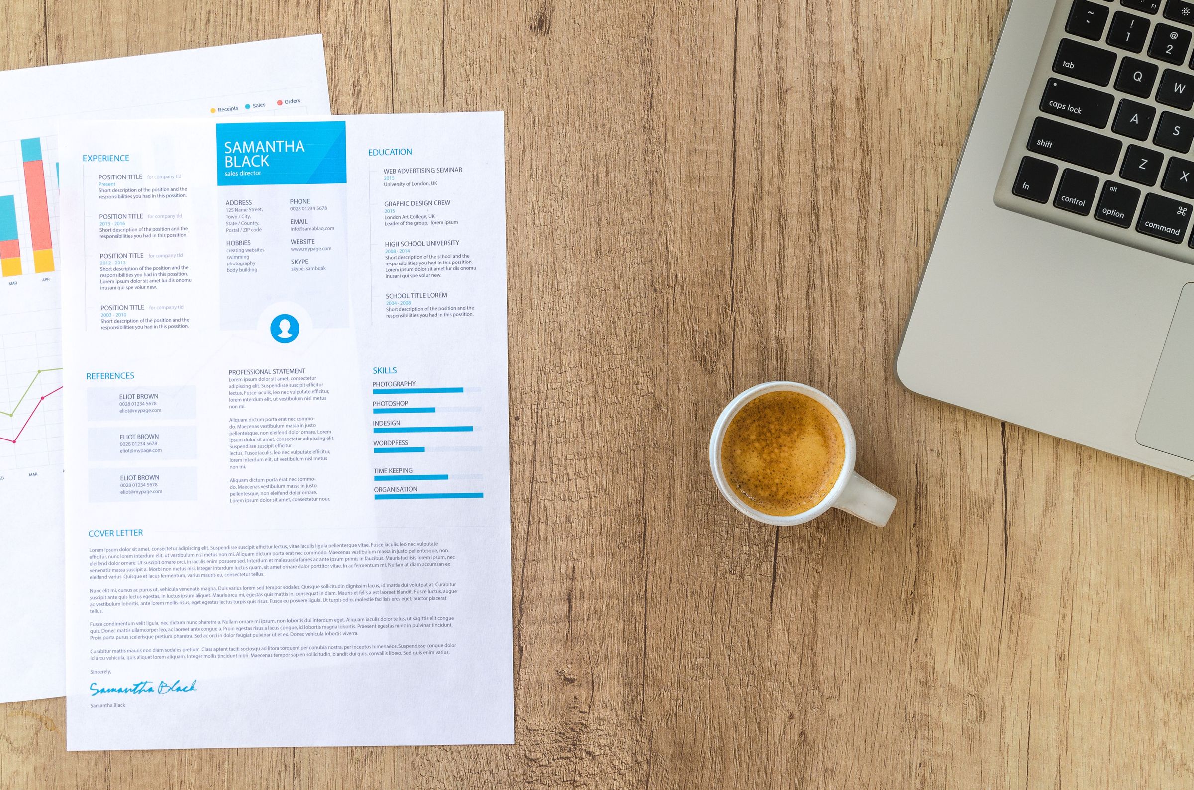 Printed resume with experience and skills beside a laptop