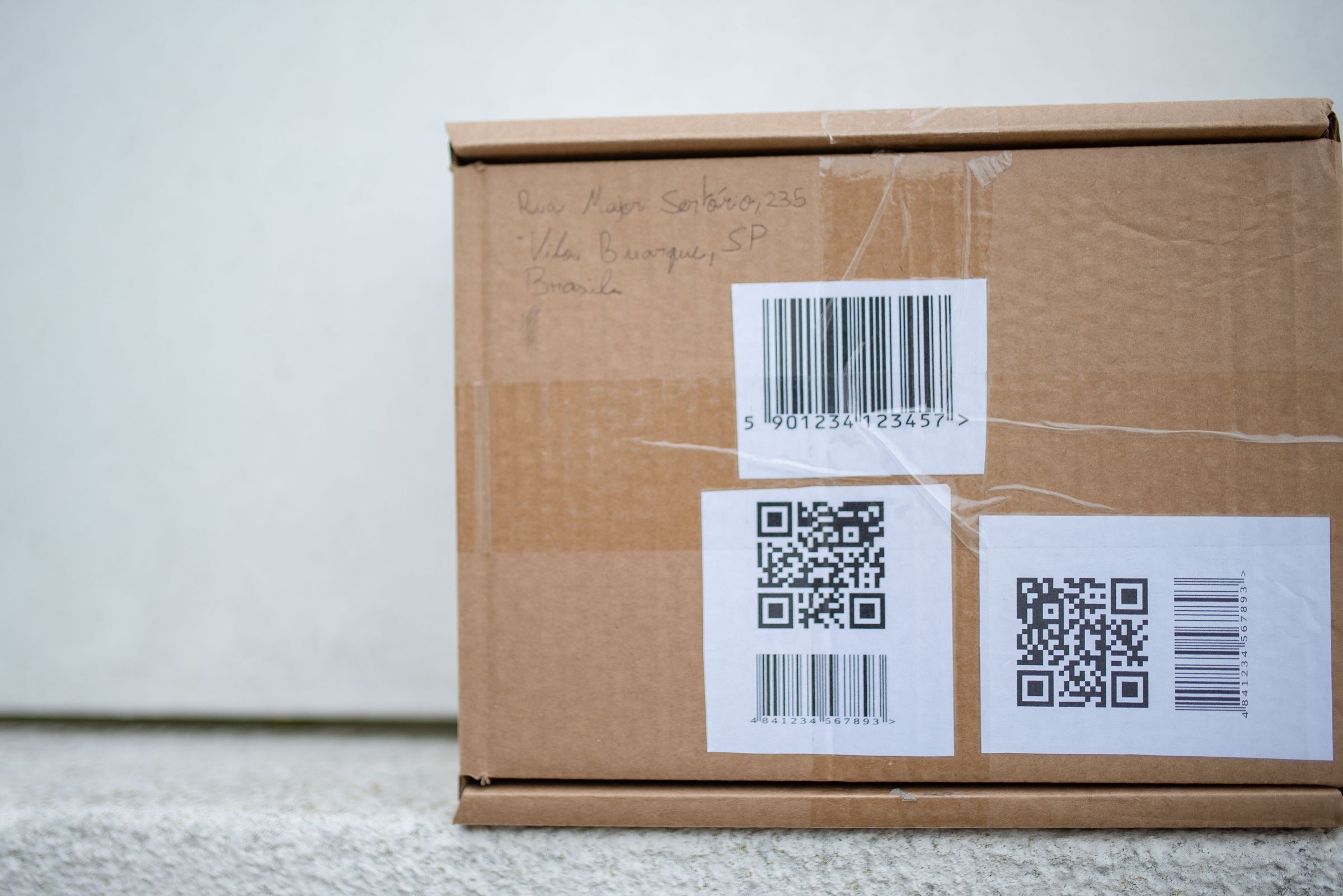 Cardboard parcel with barcode and QR-code labels