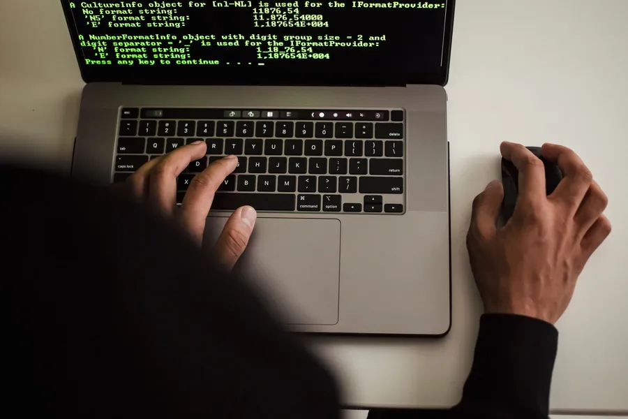 Person using a laptop displaying programming text