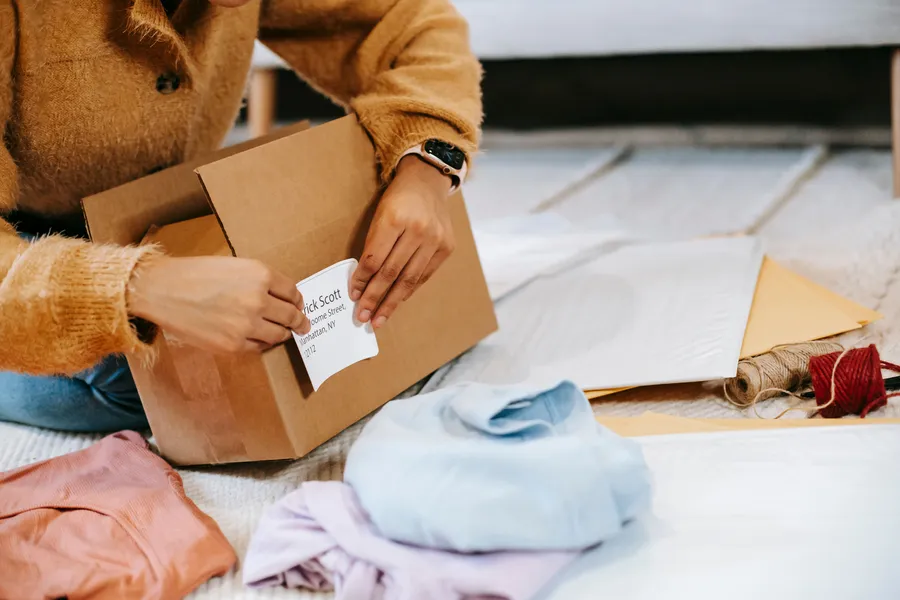 Applying an address label to a shipping box beside packing materials