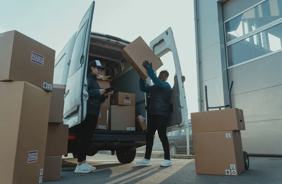Loading boxes into a delivery vehicle near a warehouse