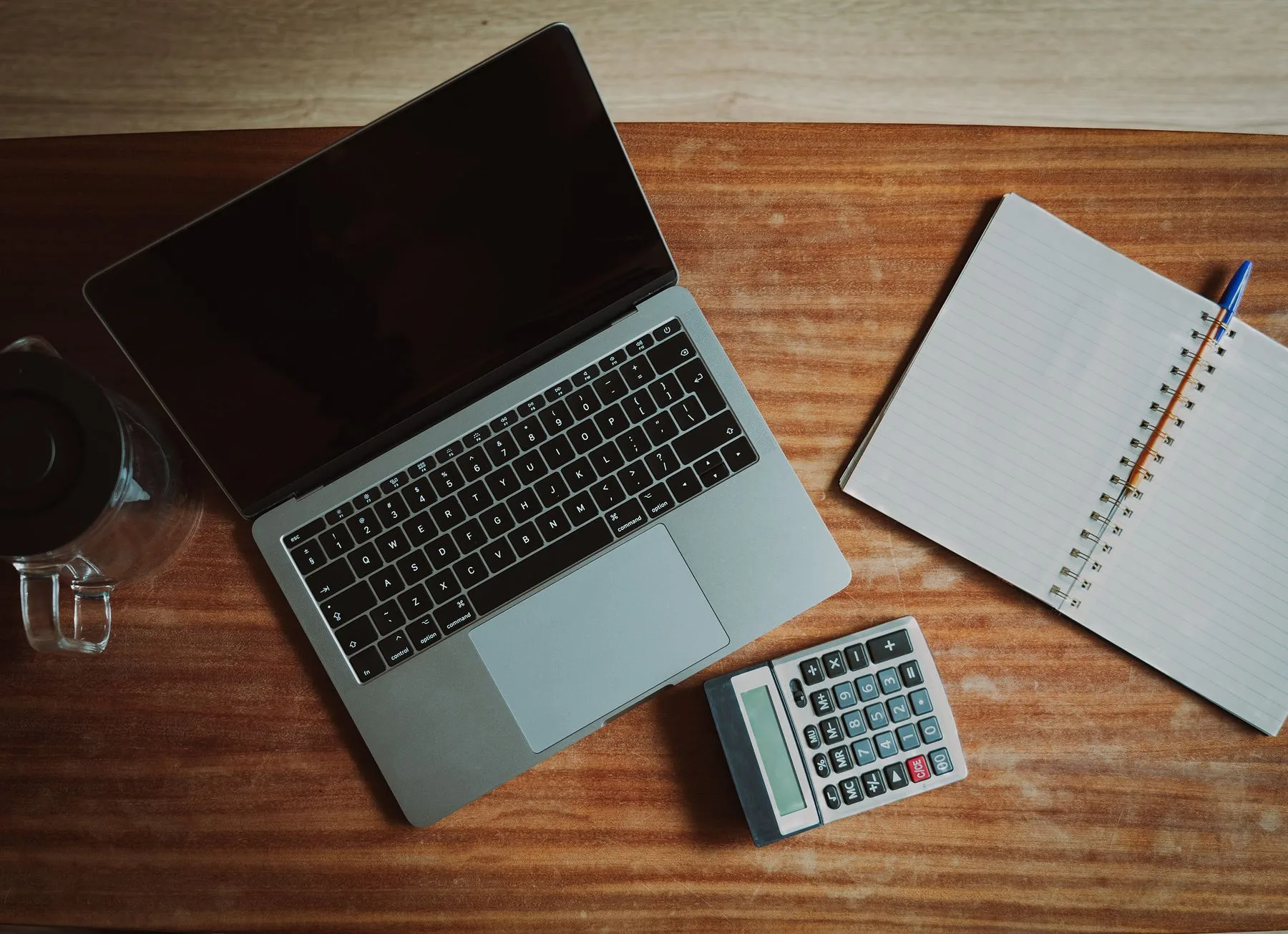 Payroll sheets and a calculator on a desk for wage and compliance review