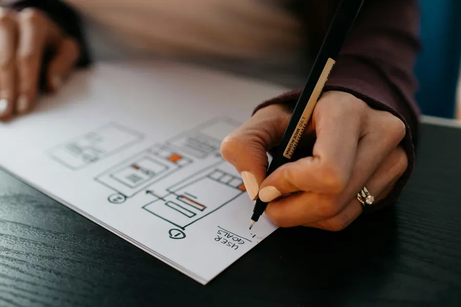 Drawing a page interface wireframe with a pen on paper