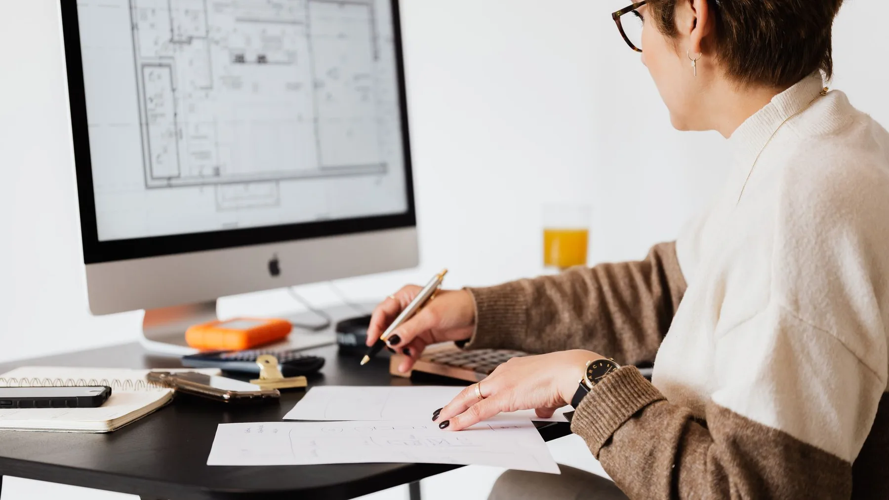 Property professional reviewing a floor plan on a computer