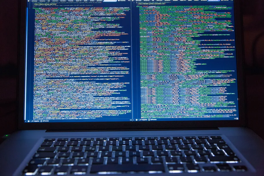 Laptop displaying JavaScript and CSS files in a code editor