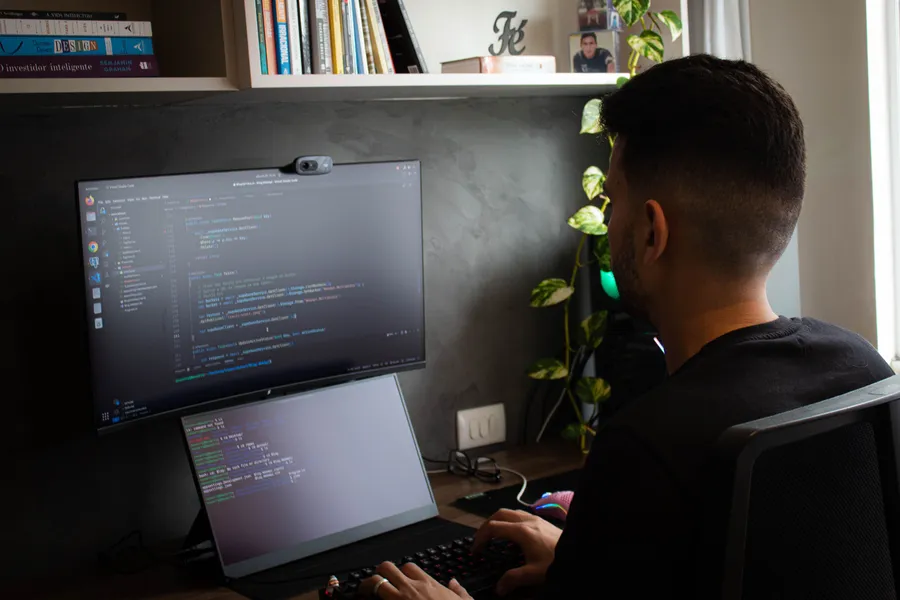 Person working at a computer in a programming workspace